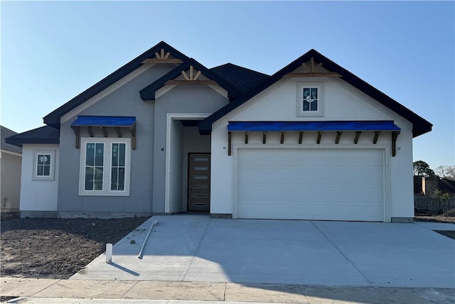 view of front of house featuring stucco siding, a garage, and driveway