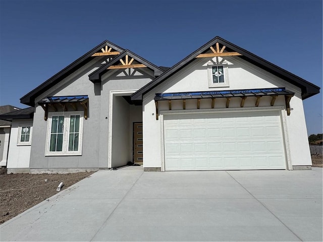 view of front facade featuring stucco siding, a garage, and driveway