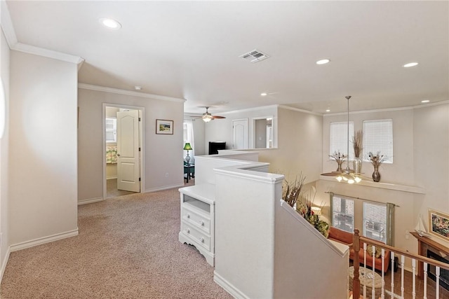 hall featuring crown molding, visible vents, baseboards, and an upstairs landing
