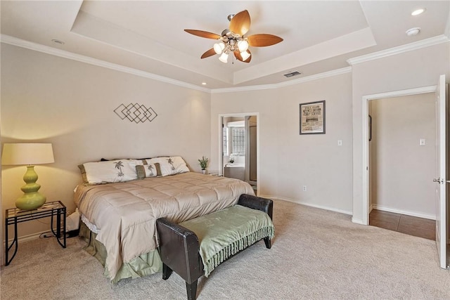 carpeted bedroom with visible vents, baseboards, a raised ceiling, ceiling fan, and crown molding