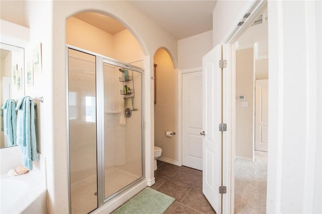 full bathroom with a bath, tile patterned flooring, toilet, and a stall shower