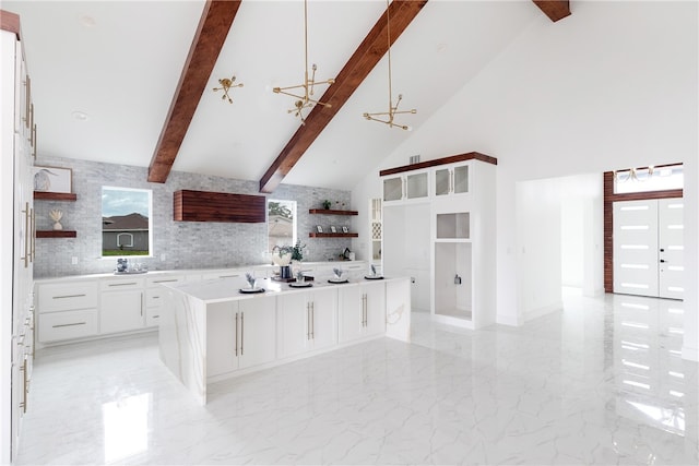 kitchen with a center island, white cabinets, a notable chandelier, high vaulted ceiling, and beamed ceiling