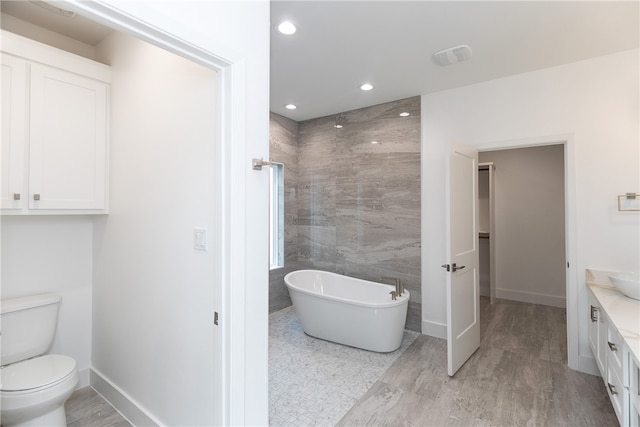 full bathroom featuring tile walls, wood-type flooring, vanity, independent shower and bath, and toilet