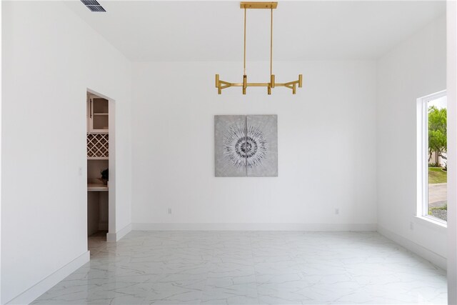 13974 Blackbeard Dr, Corpus Christi, TX 78418 - unfurnished room with marble finish floors, a chandelier, and baseboards