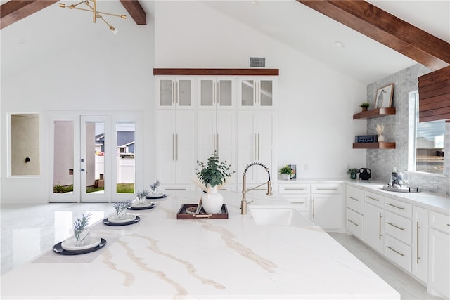 kitchen featuring white cabinets, a wealth of natural light, and sink