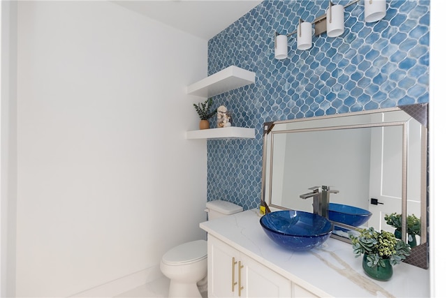 bathroom featuring vanity, toilet, and tile walls