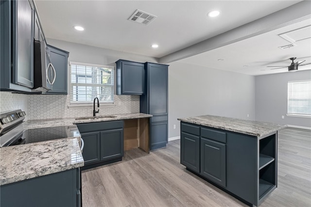 kitchen with a wealth of natural light, stainless steel appliances, light hardwood / wood-style floors, and a center island