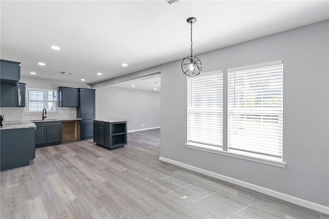 kitchen featuring hardwood / wood-style floors, hanging light fixtures, a healthy amount of sunlight, and decorative backsplash