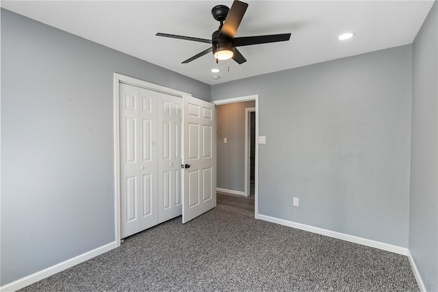 unfurnished bedroom featuring ceiling fan, dark colored carpet, and a closet