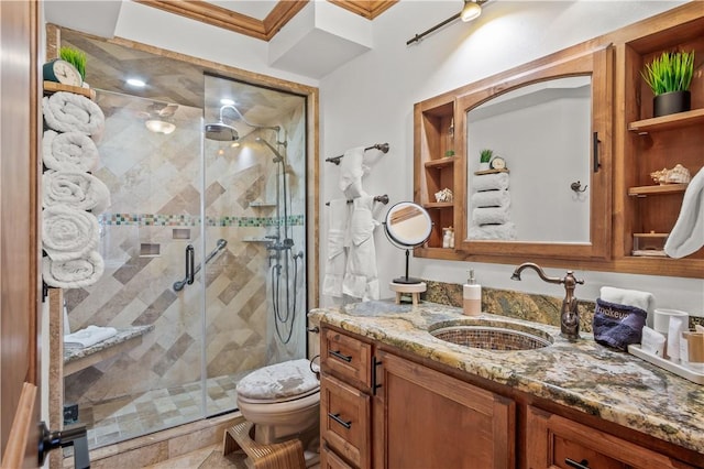 bathroom featuring crown molding, vanity, toilet, and a shower with door