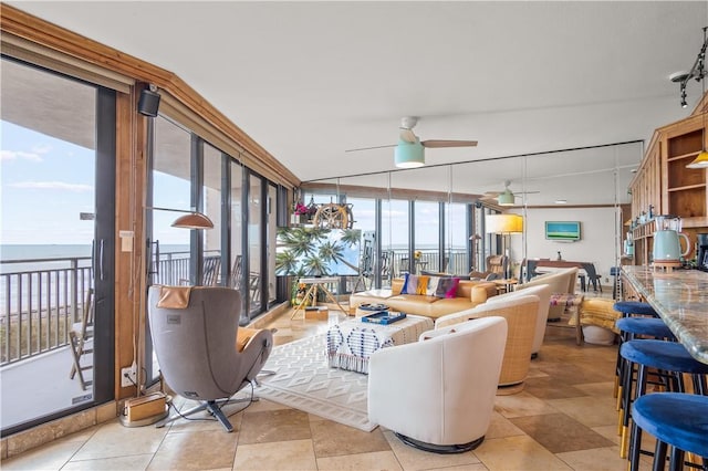 sunroom featuring ceiling fan and a water view