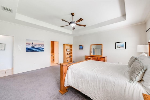 6041 King Trl, Corpus Christi, TX 78414 - bedroom featuring a tray ceiling, carpet flooring, baseboards, ensuite bath, and a ceiling fan