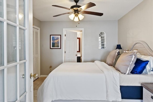 bedroom featuring ceiling fan, light tile patterned floors, and a closet