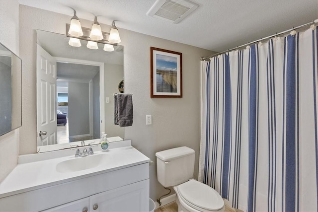 bathroom with toilet, a textured ceiling, and vanity