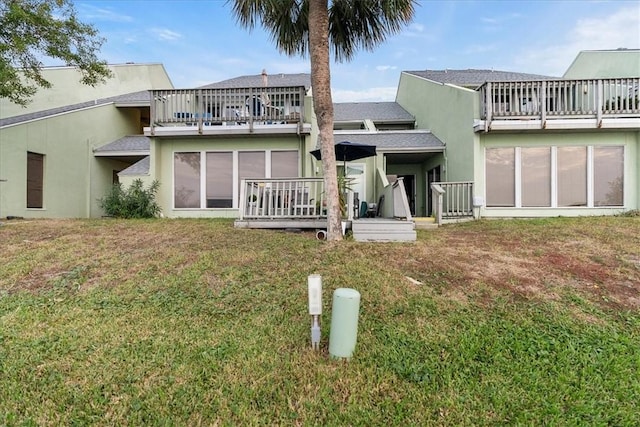 back of property featuring a deck and a yard