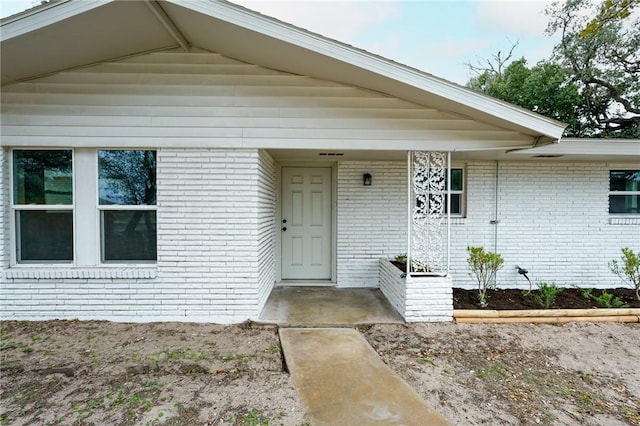 doorway to property with brick siding