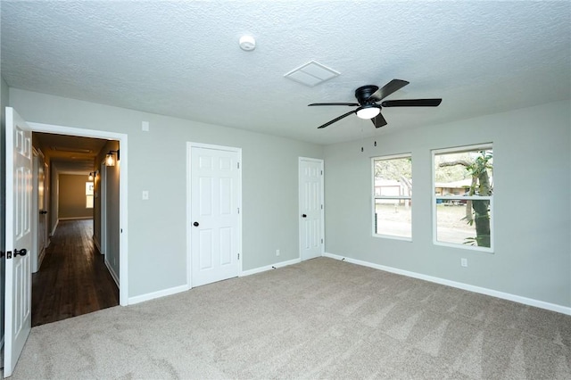 unfurnished bedroom featuring carpet floors, a textured ceiling, and baseboards