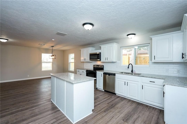 kitchen featuring stainless steel appliances, white cabinets, a sink, and dark wood-style floors