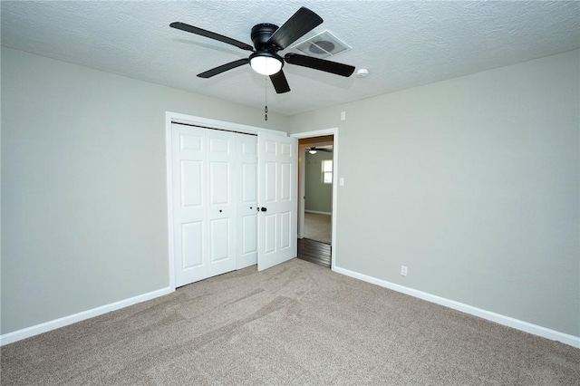 unfurnished bedroom with light carpet, baseboards, visible vents, and a textured ceiling