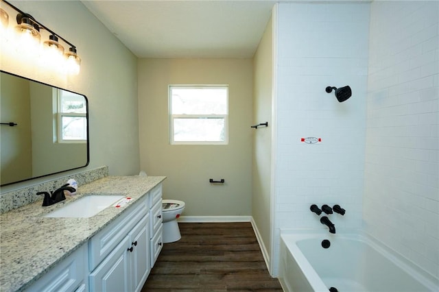 bathroom with toilet, washtub / shower combination, vanity, wood finished floors, and baseboards