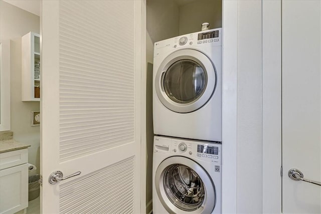 clothes washing area with stacked washer / dryer