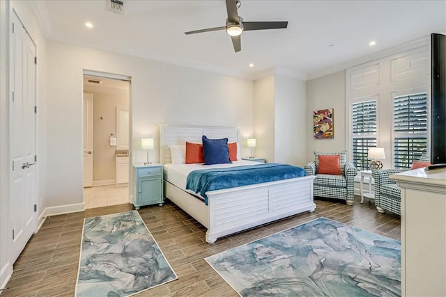 bedroom featuring ceiling fan, ensuite bathroom, and crown molding