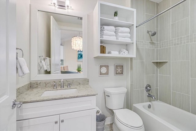 full bathroom featuring toilet, an inviting chandelier, tiled shower / bath combo, and vanity