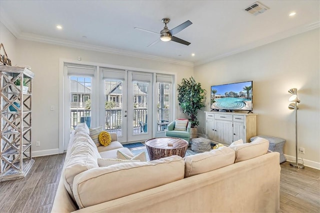 living room featuring ceiling fan, french doors, ornamental molding, and light hardwood / wood-style flooring