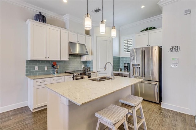 kitchen with sink, white cabinets, stainless steel appliances, and a kitchen island with sink