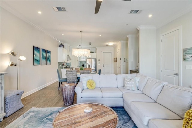 living room with ceiling fan, wood-type flooring, and crown molding