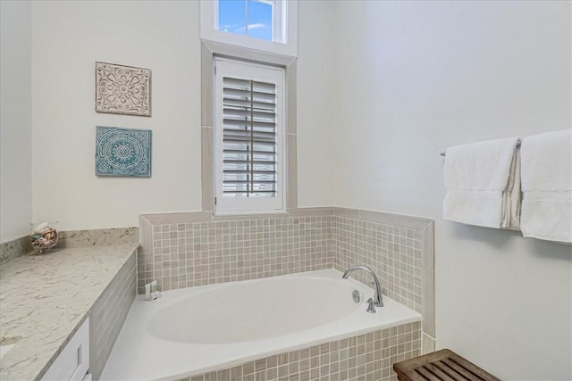 bathroom with tiled bath and vanity