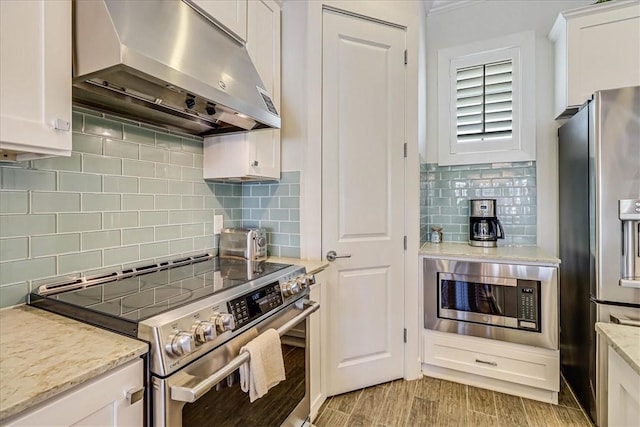 kitchen with decorative backsplash, white cabinets, and stainless steel appliances