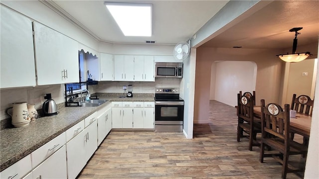 kitchen with pendant lighting, white cabinetry, sink, and appliances with stainless steel finishes