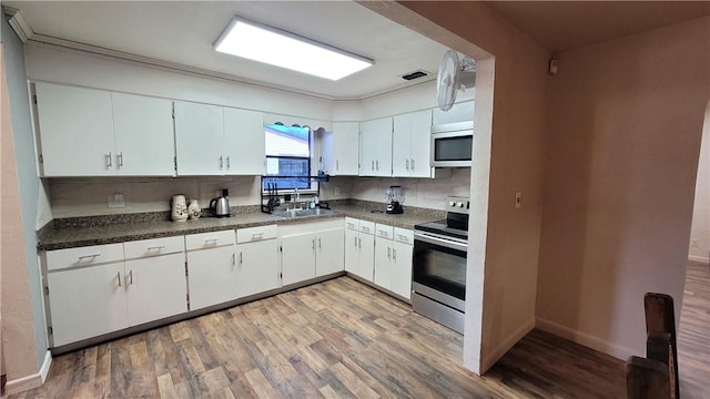 kitchen with light hardwood / wood-style floors, white cabinetry, sink, and appliances with stainless steel finishes