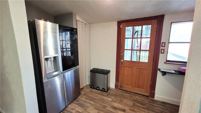 entryway with a textured ceiling, plenty of natural light, and dark wood-type flooring