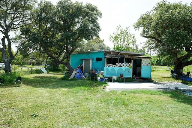 rear view of property featuring a yard