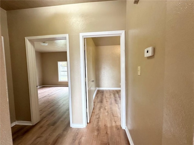 hallway with light hardwood / wood-style flooring