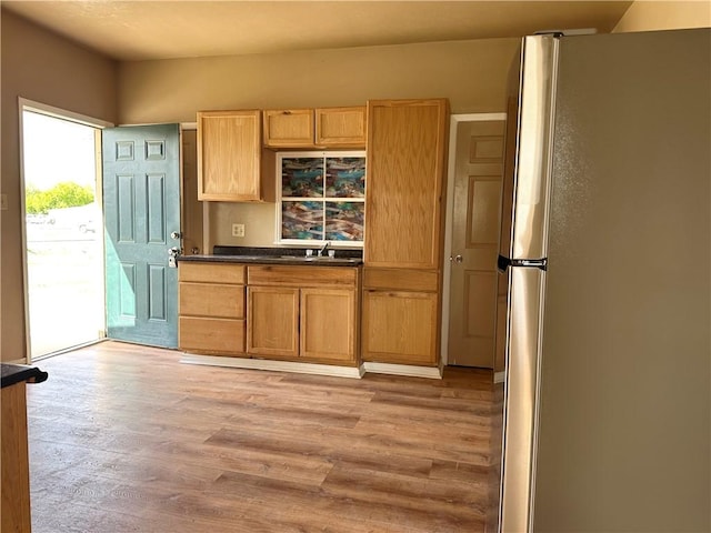 616 Hall St Unit A & B, Sinton, TX 78387 - kitchen with a sink, light wood-type flooring, dark countertops, and freestanding refrigerator