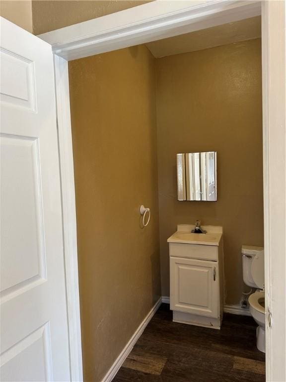 bathroom featuring toilet, hardwood / wood-style floors, and vanity