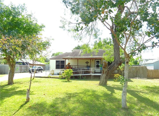 rear view of property featuring a lawn and a porch