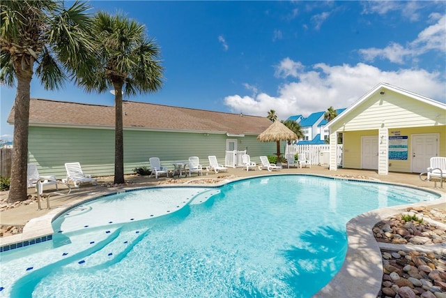 pool with a patio area and fence