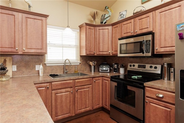 kitchen with tasteful backsplash, appliances with stainless steel finishes, light countertops, and a sink