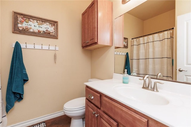 bathroom featuring baseboards, vanity, and toilet