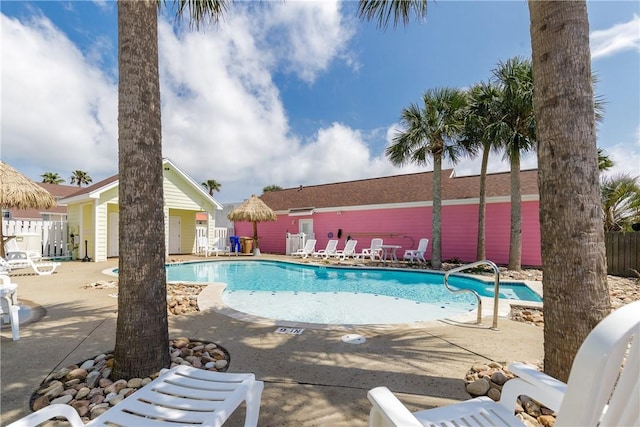 community pool featuring a patio and fence