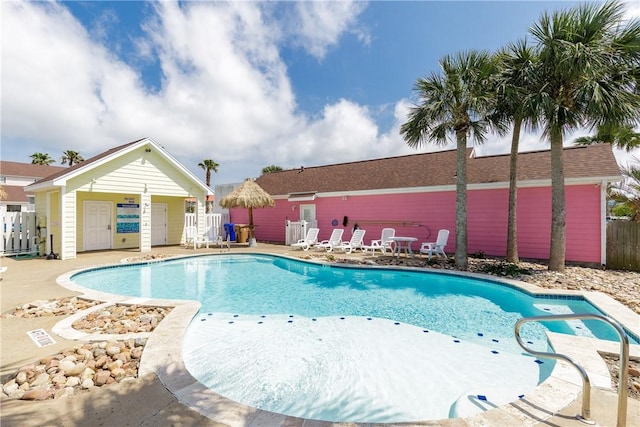 pool featuring fence and a patio