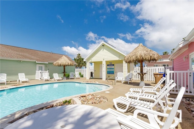 pool with a patio area and fence