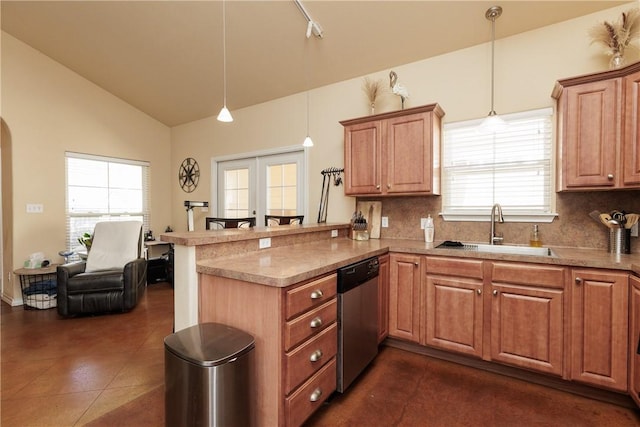 kitchen featuring a peninsula, a sink, stainless steel dishwasher, and hanging light fixtures