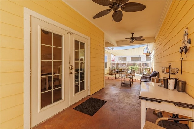 entryway with concrete flooring, french doors, a ceiling fan, and wooden walls