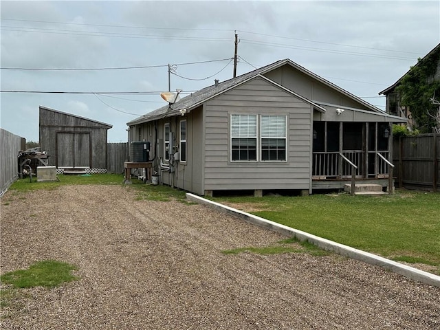 230 Lola Johnson, Corpus Christi, TX 78418 - view of home's exterior with a storage shed, a sunroom, a yard, fence, and an outbuilding