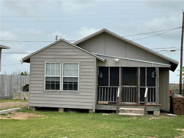 230 Lola Johnson, Corpus Christi, TX 78418 - rear view of house featuring a lawn, a sunroom, and fence